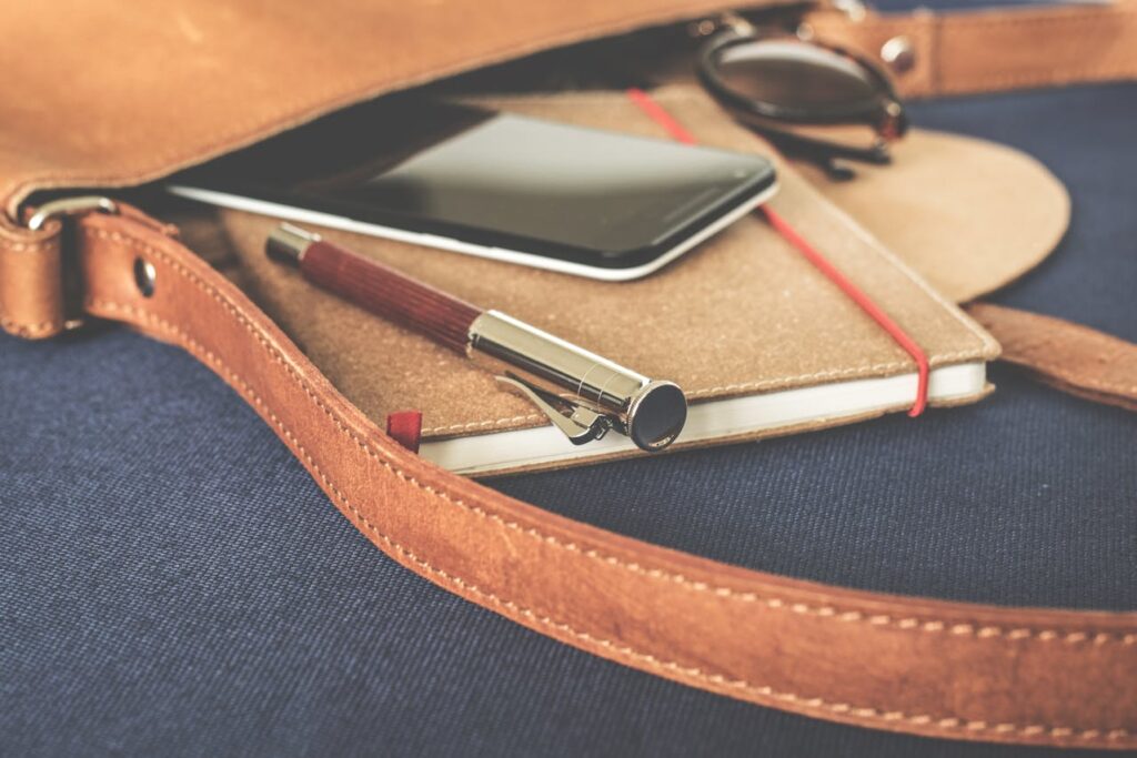Tasche mit Notizbuch, Stift,Telefon und Sonnenbrille